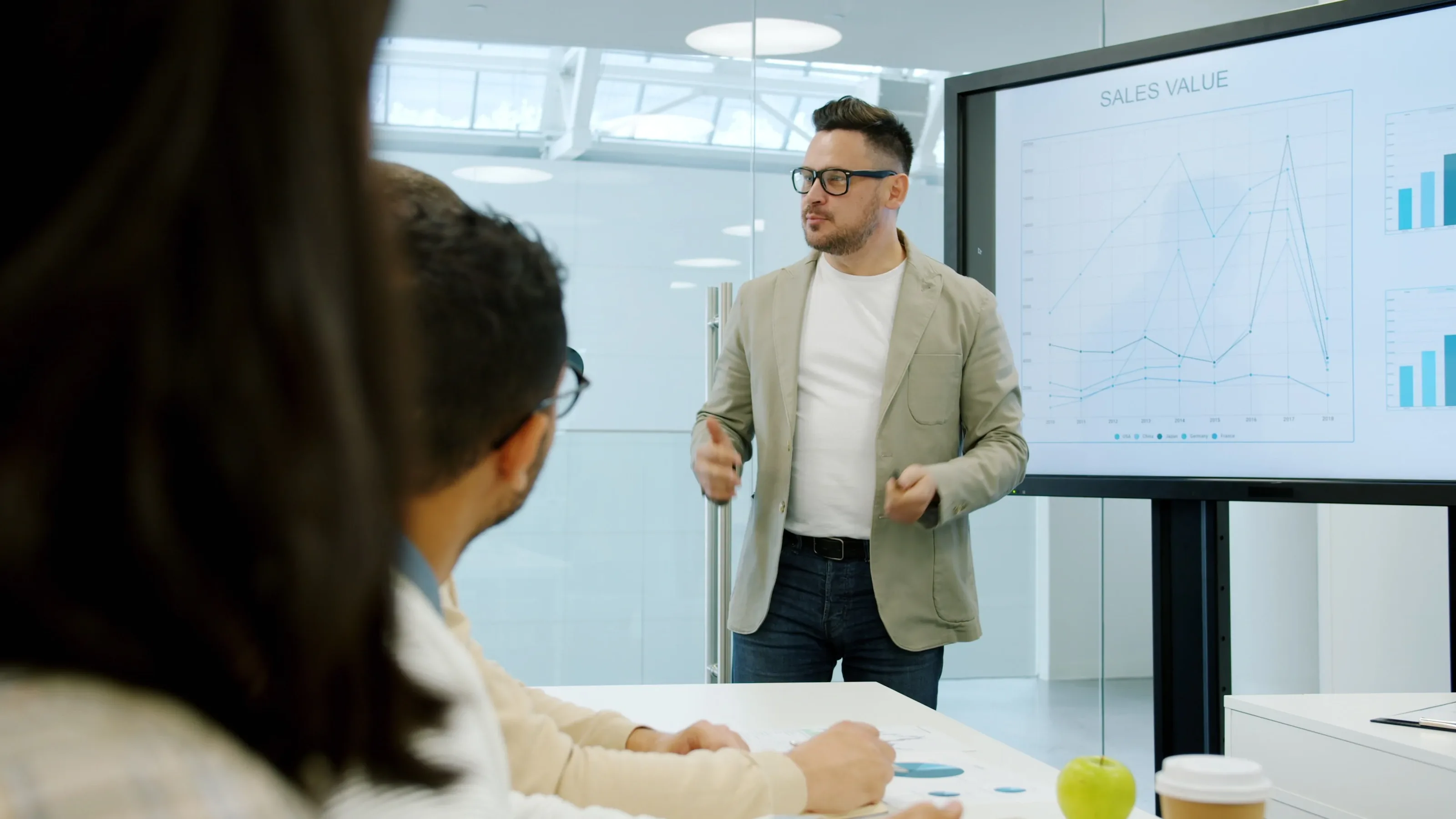 Delegates listening to a trainer standing beside a presentation screen