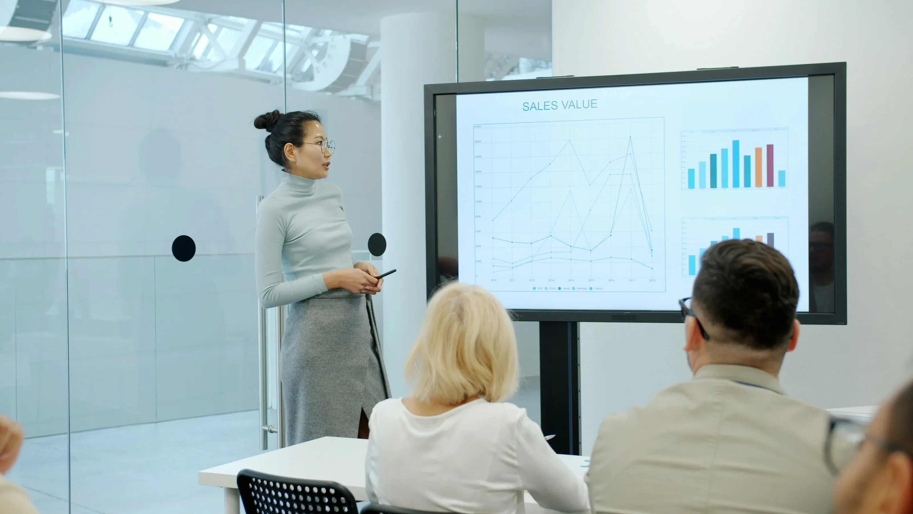 Trainer presenting to delegates in a glass-walled training room